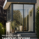 Véranda en verre moderne intégrée à une maison contemporaine, offrant une luminosité naturelle.