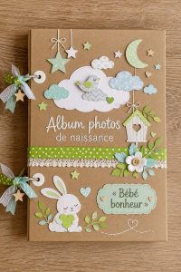 Album photo de naissance sur une table avec des décorations féeriques.