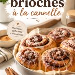 Brioches à la cannelle moelleuses sur une assiette, entourées de cannelle en poudre et de sucre juste saupoudré.